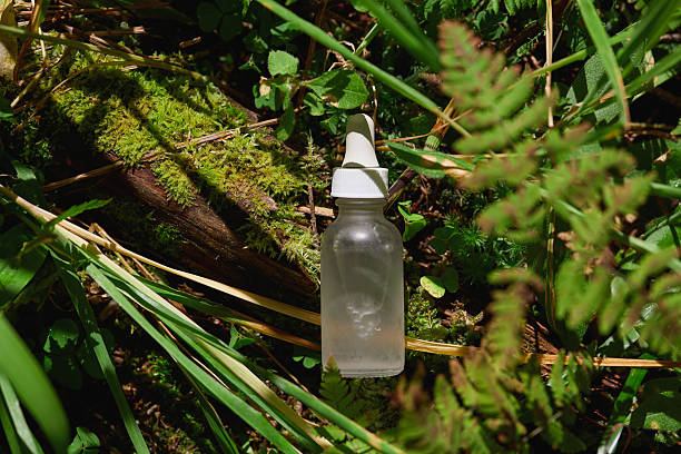 istock Clear dropper bottle nestled among green foliage in a forest setting 2206952968