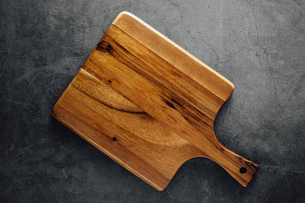 istock Rustic Wooden Cutting Board on Dark Stone Surface for Culinary and Kitchen Use 2206956275
