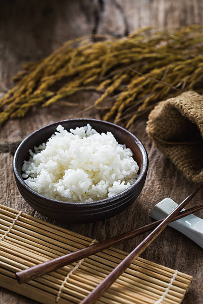 istock Freshly Cooked White Rice in Wooden Bowl with Chopsticks and Natural Decor Elements 2206956329