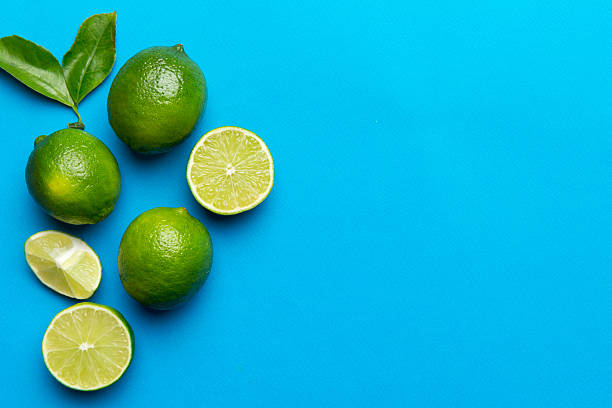 istock Lime fruits with green leaf and cut in half slice isolated on white background. Top view. Flat lay with copy space 2206956786