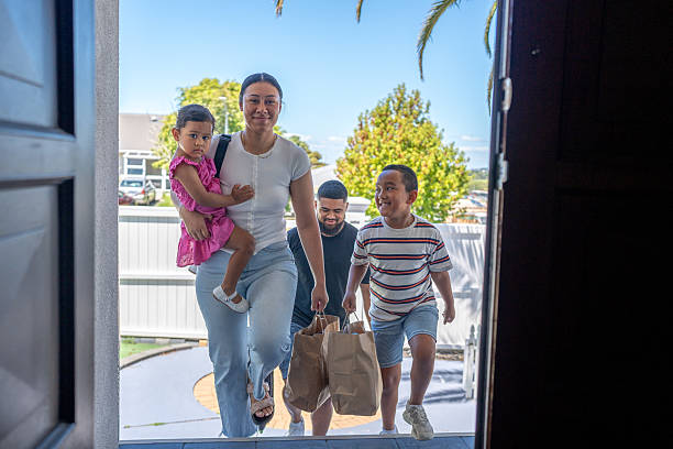 A Pacific Islander family walks through the front door of their home