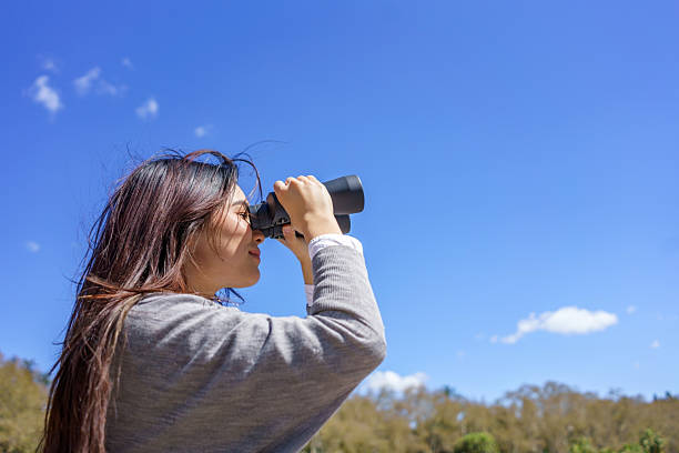 istock Young japanese woman looking through binoculars in nature 2206957296