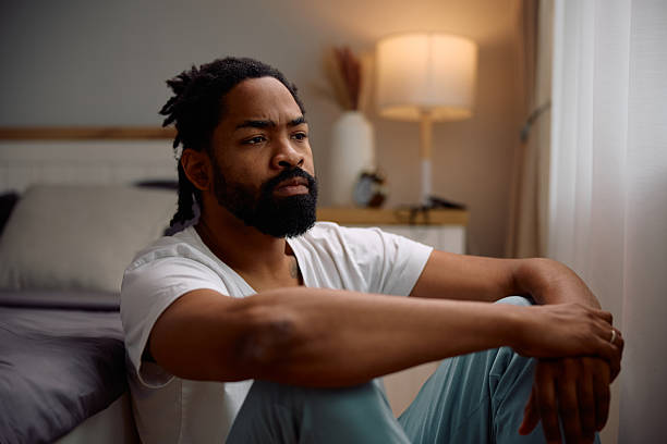 istock African American man thinking of something while sitting in bedroom. 2206958992