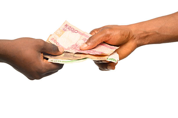 istock Close-Up of Hands Exchanging Nigerian Naira Banknotes 2206960749