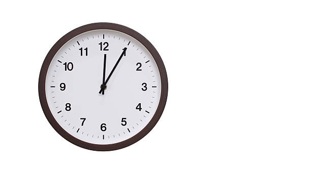 istock A simple round wall clock with a dark brown frame and a white face displaying 12.05 or 00.05. Isolated on a white background, perfect for time-related concepts, deadlines, and schedule themes. 2206961180