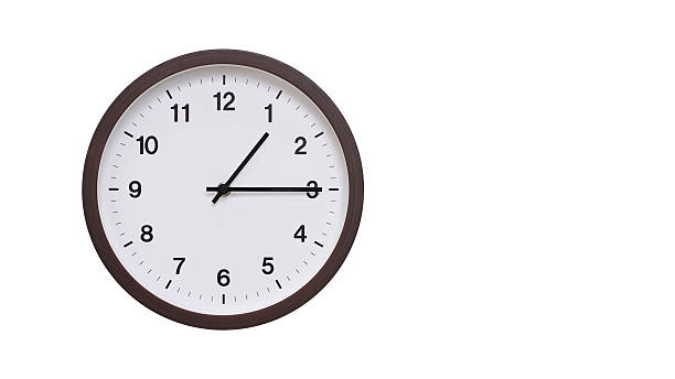 istock A simple round wall clock with a dark brown frame and a white face displaying 01.15/13.15. Isolated on a white background, perfect for time-related concepts, deadlines, and schedule themes. 2206961217