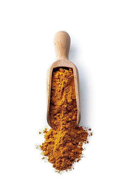 Ground turmeric in a wooden scoop