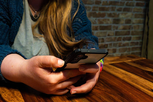 istock Mom using smartphone in cozy setting, relaxed atmosphere with wooden table and brick wall background 2206961755
