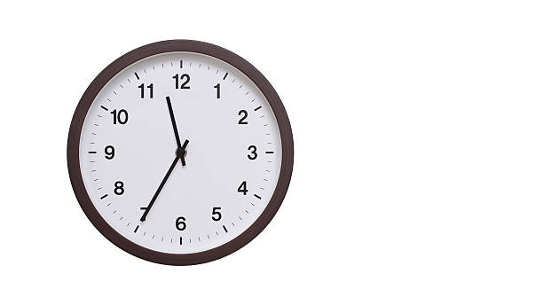 istock A simple round wall clock with a dark brown frame and a white face displaying 11.35/23.35. Isolated on a white background, perfect for time-related concepts, deadlines, and schedule themes. 2206961969