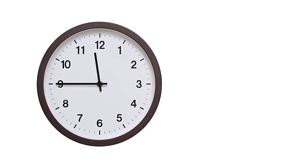 istock A simple round wall clock with a dark brown frame and a white face displaying 11.45/23.45. Isolated on a white background, perfect for time-related concepts, deadlines, and schedule themes. 2206961990
