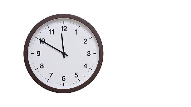 istock A simple round wall clock with a dark brown frame and a white face displaying 11.50/23.50. Isolated on a white background, perfect for time-related concepts, deadlines, and schedule themes. 2206962001