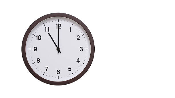 istock A simple round wall clock with a dark brown frame and a white face displaying 23.00/11.00. Isolated on a white background, perfect for time-related concepts, deadlines, and schedule themes. 2206962203