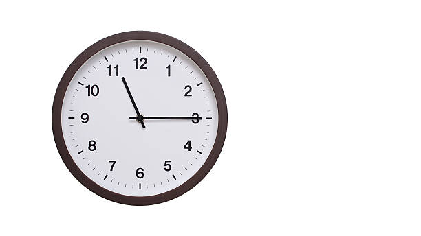 istock A simple round wall clock with a dark brown frame and a white face displaying 11.15/23.15. Isolated on a white background, perfect for time-related concepts, deadlines, and schedule themes. 2206962208