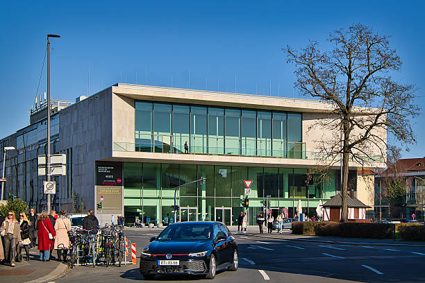 Wuerzburg, Germany - March 16, 2025: Pedestrians and traffic in front of the Mainfrankentheater in Würzburg.