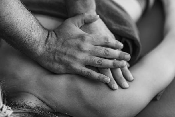 Physical therapist performs a deep tissue massage on a patients shoulder to relieve muscle tension and improve mobility in a therapeutic setting