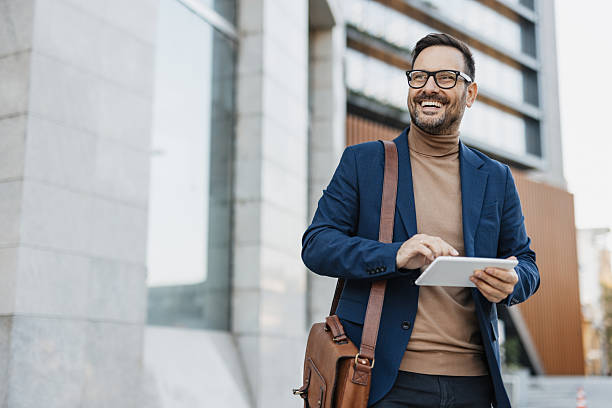 istock Cheerful man walking with tablet in business attire. 2206971914