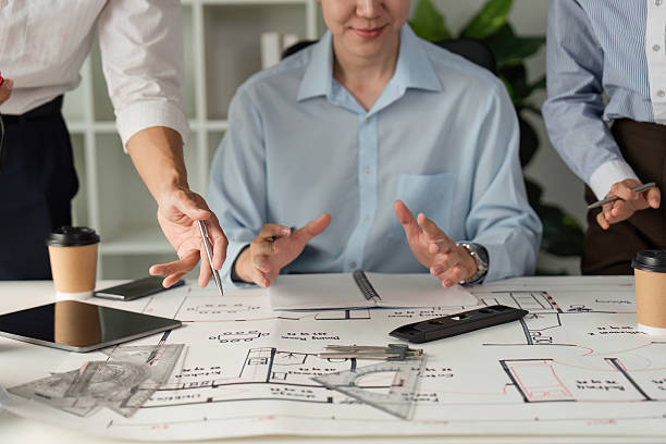 istock Teamwork and Strategy. Close-up of professionals engaged in discussion over architectural plans. 2206972201