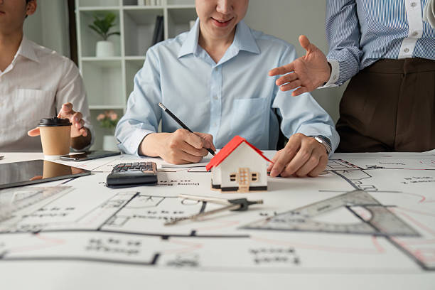istock Team Collaboration and Architectural Planning. Professionals collaborating on building design, reviewing plans and models. 2206972495