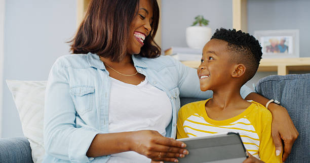istock Tablet, bonding and mother with child on sofa playing educational game online for learning. Happy, relax and mom with boy kid on digital technology for entertainment in living room in home together. 2206972874