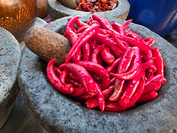 Fresh red chili peppers in stone mortar