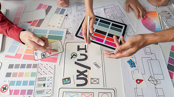 istock UX Design and Collaboration. Creative professionals brainstorming UI/UX concepts on a design table. 2206974367