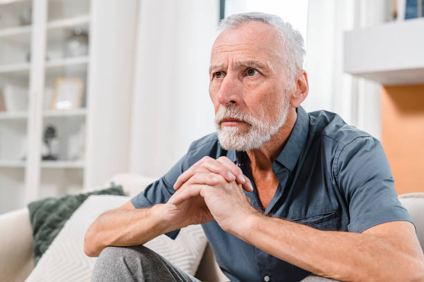 istock Thoughtful Senior Man Sitting Indoors in a Comfortable Home Setting 2206974368
