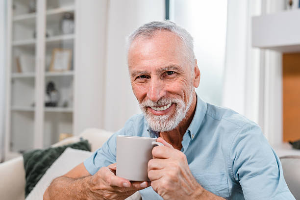 istock Senior Man Smiling While Enjoying a Hot Beverage in a Cozy Home 2206974389