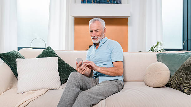 istock Senior Man Relaxing at Home and Using a Smartphone on the Sofa 2206974495