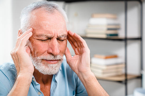 istock Senior Man Experiencing Headache Holding Temples in a Home Environment 2206974694