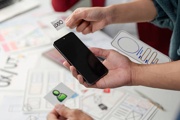 istock Design Elements and Branding in UX. Team members conceptualizing designs with prototypes in hand, ready to innovate. 2206974714