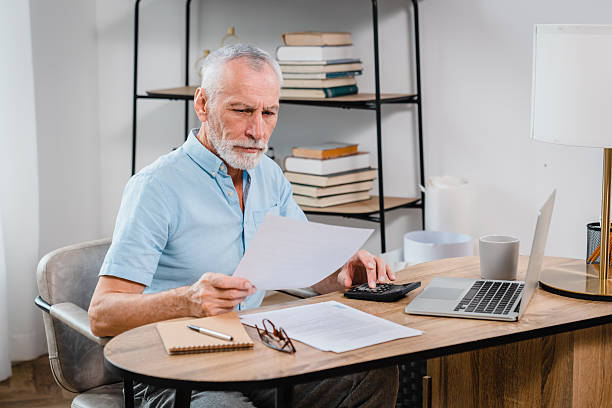 istock Senior Man Analyzing Financial Documents at Home Office Desk 2206974772