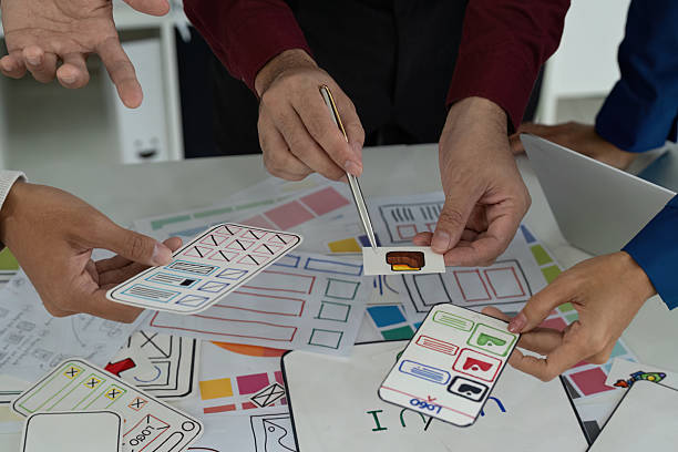 istock Creative Teamwork in UX UI Design. Designers engaging in a lively discussion over digital prototypes and sketches. 2206975198