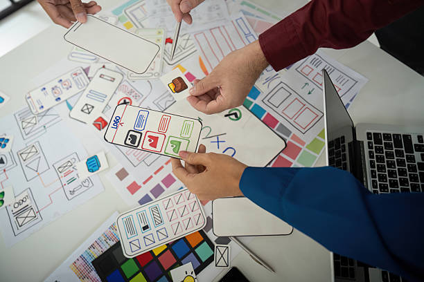 istock Team Coordination and Idea Exchange. Designers sharing layouts and feedback in an interactive session for UI design. 2206975525