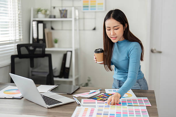 istock Productivity and Color Analysis. A designer assesses color samples while enjoying her coffee in a stylish workspace. 2206977413