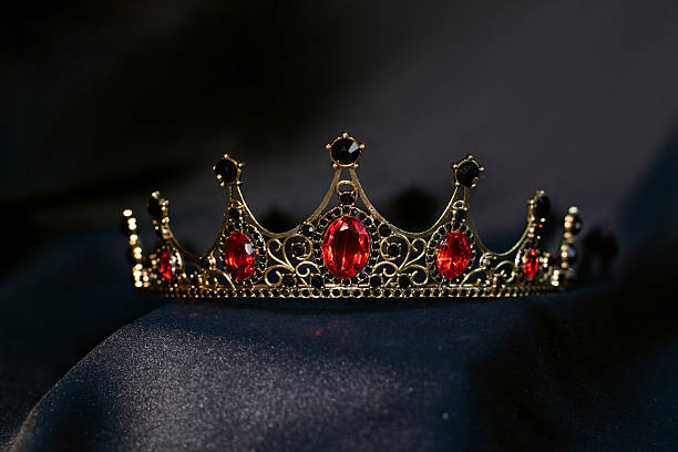 istock Luxury golden crown with red gemstones and diamonds on dark background. 2206977752