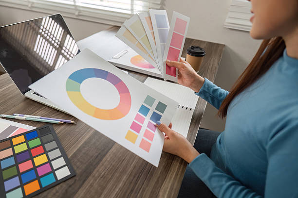 istock Color Evaluation and Design Creation. An artist analyzing color schemes and refining design elements at her desk. 2206977969
