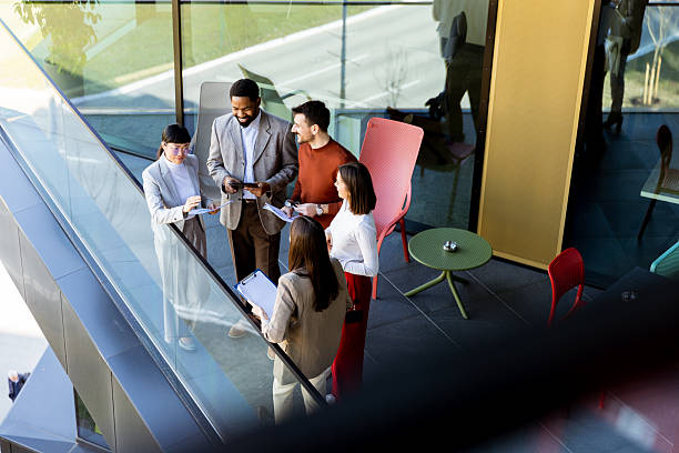 istock Group of professionals collaborating on project details in modern office space during sunny day 2206980503