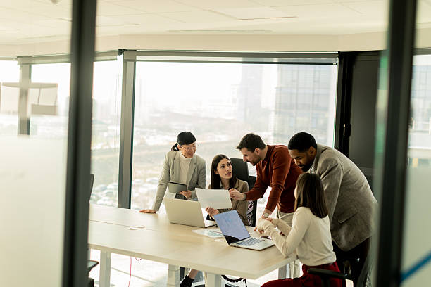 istock Team collaborates in modern office setting on innovative project with laptops and discussion 2206980516