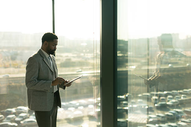 istock Business professional engages with a tablet while enjoying a sunny afternoon by a large window 2206980518