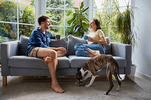 istock Couple at home sitting on sofa having coffee talking 2206981196