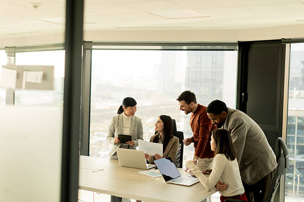 istock Team collaborates in modern office setting on innovative project with laptops and discussion 2206982538