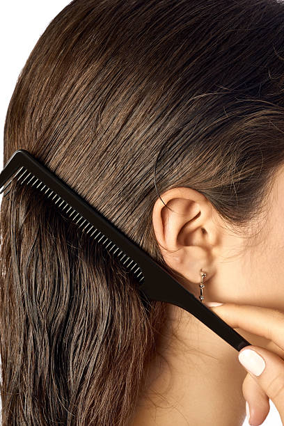 istock A person is gently combing through wet, dark brown hair using a black comb 2206982812