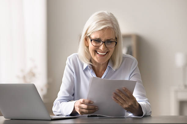 istock Older woman read document about positive financial statement 2206983232