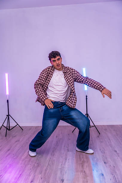 istock Young male dancer performing in a dance studio with colorful lighting 2206983961