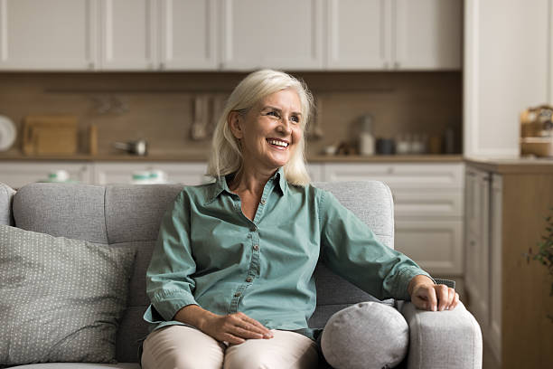 istock Smiling older female resting on comfortable sofa in studio apartment 2206985077