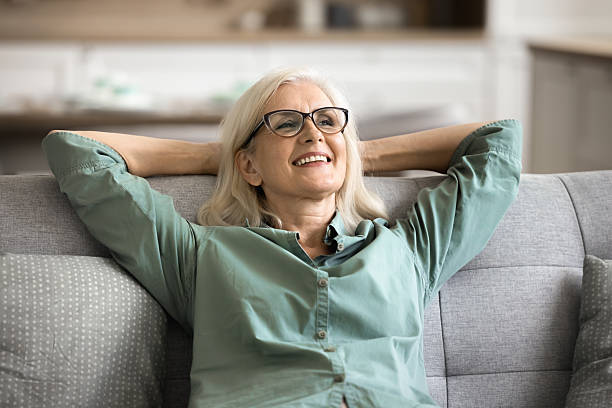 istock Satisfied older woman resting leaned on soft couch 2206986320