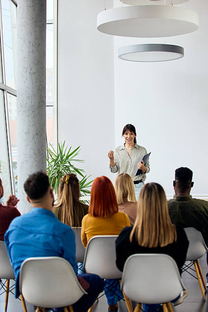 istock Speaker Addressing Audience in Modern Seminar Setting with Natural Lit Background 2206986653