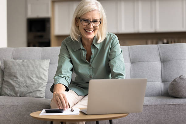 istock Smiling mature retired woman check finances, managing personal budget 2206990327