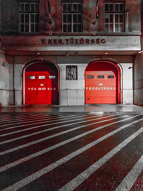 istock Historic Budapest Fire Station Showcasing Red Doors and Reflective Pavement Under Evening Light 2206990449