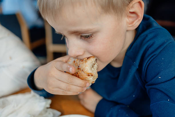 istock Young Child Enjoying a Tasty Bagel at Breakfast Table 2206990457